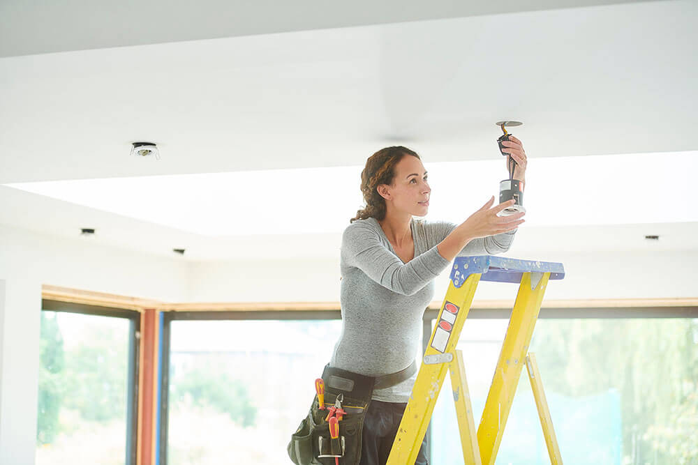 Woman wiring ceiling light
