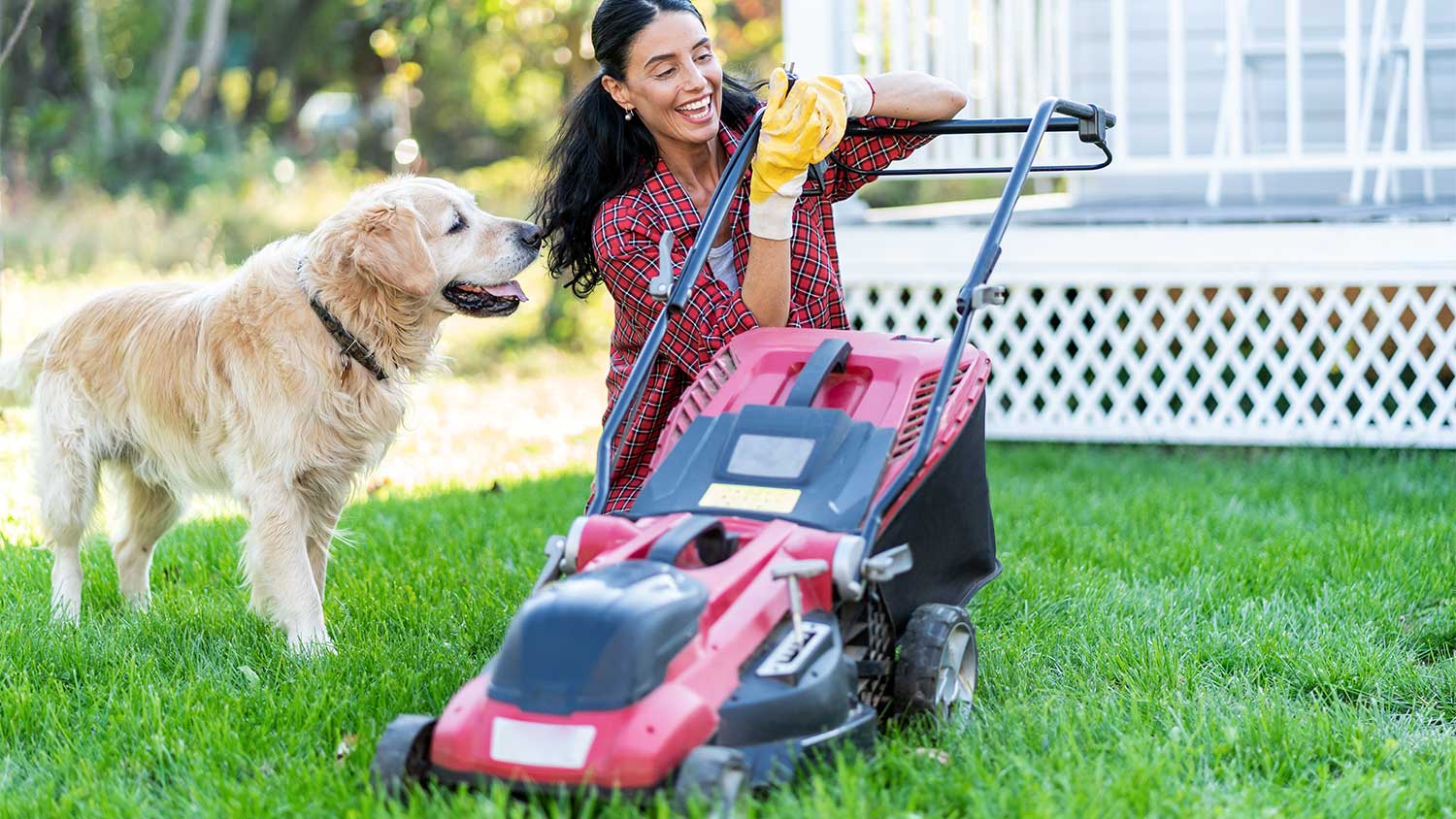 Woman with dog checking lawn mower