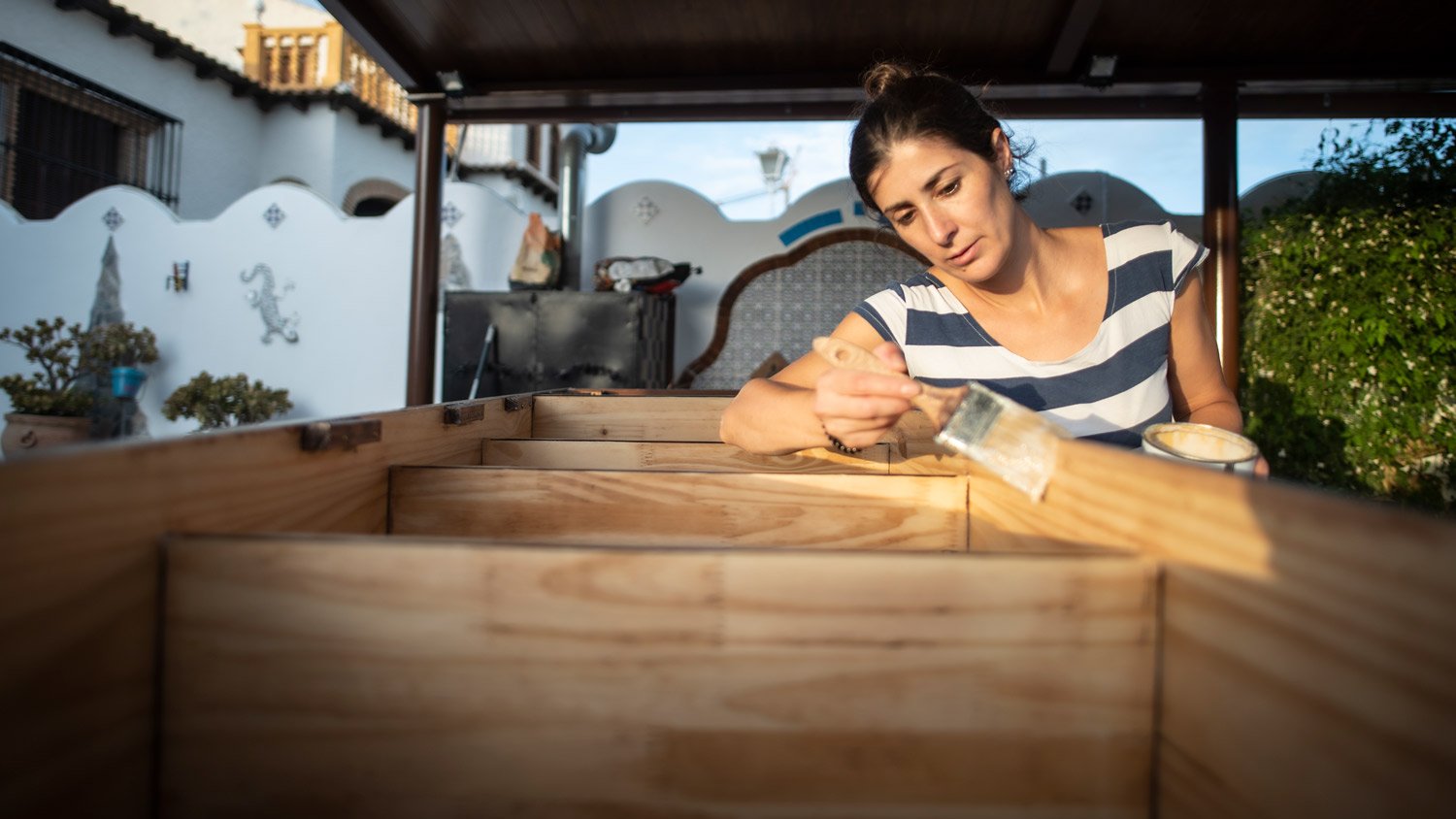 Woman varnishing and painting the renovated furniture of her house