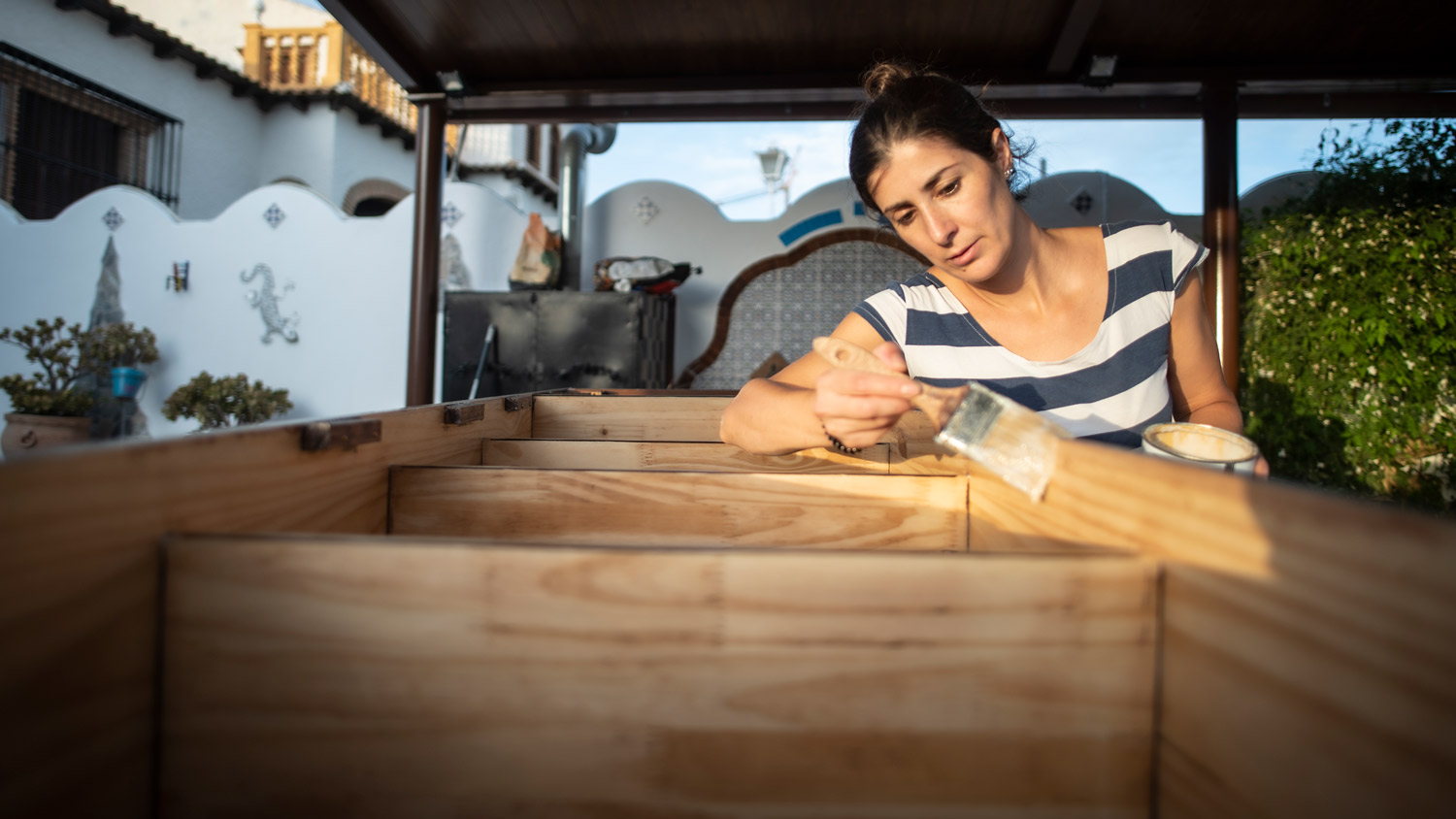 Woman varnishing and painting the renovated furniture of her house