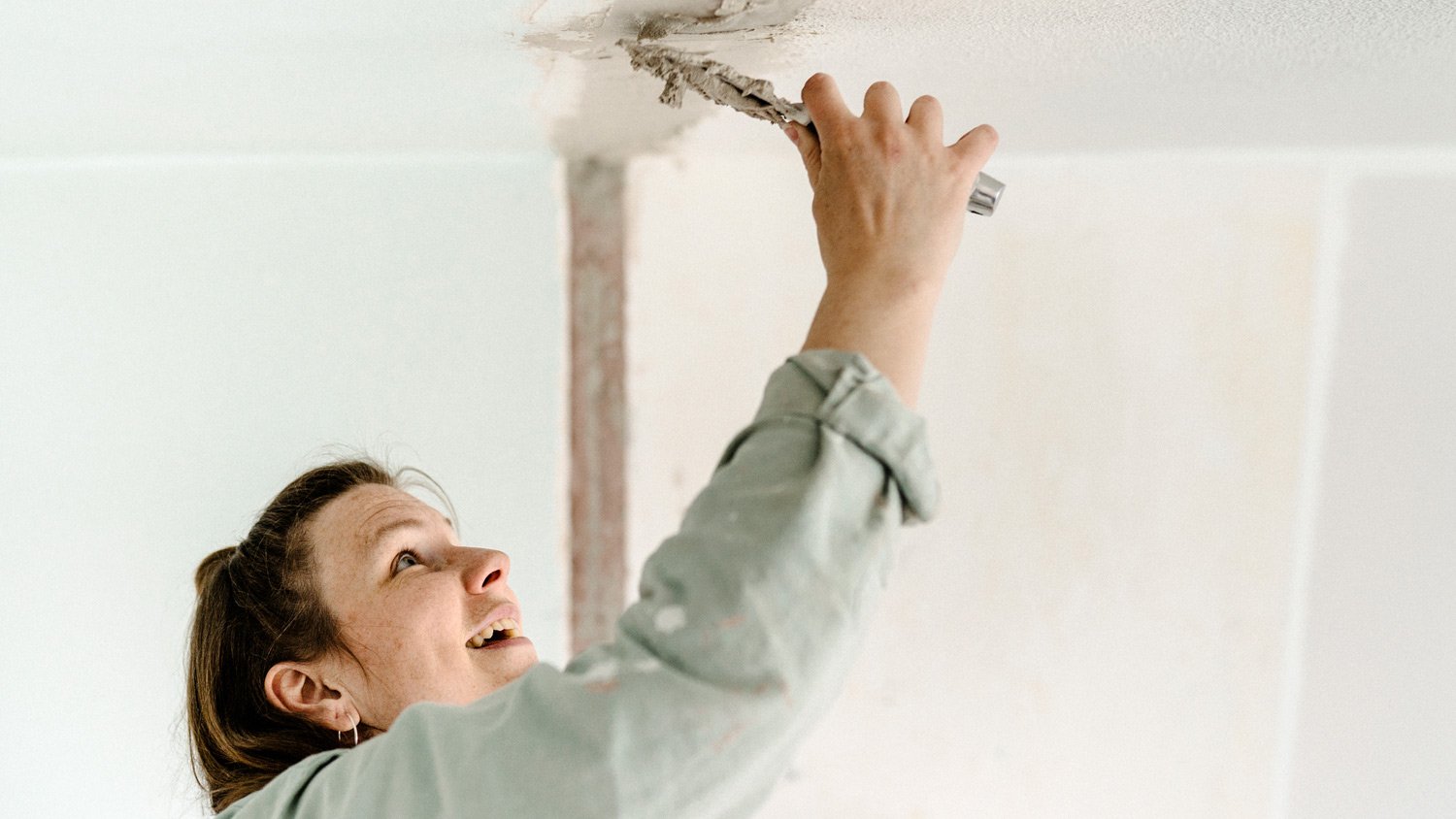 Woman repairing the ceiling
