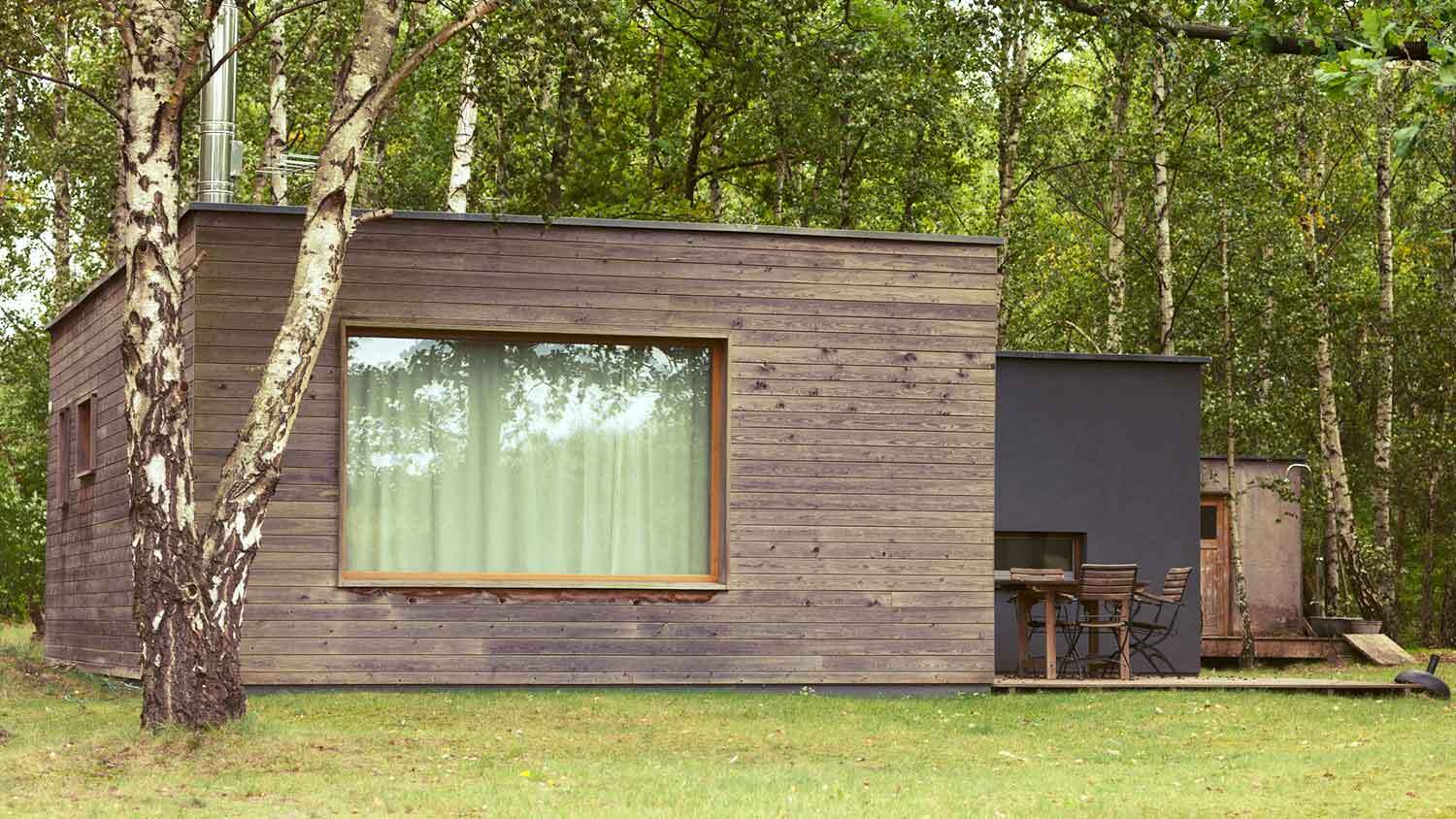 Wood cladding installed on a modern cottage in the forest