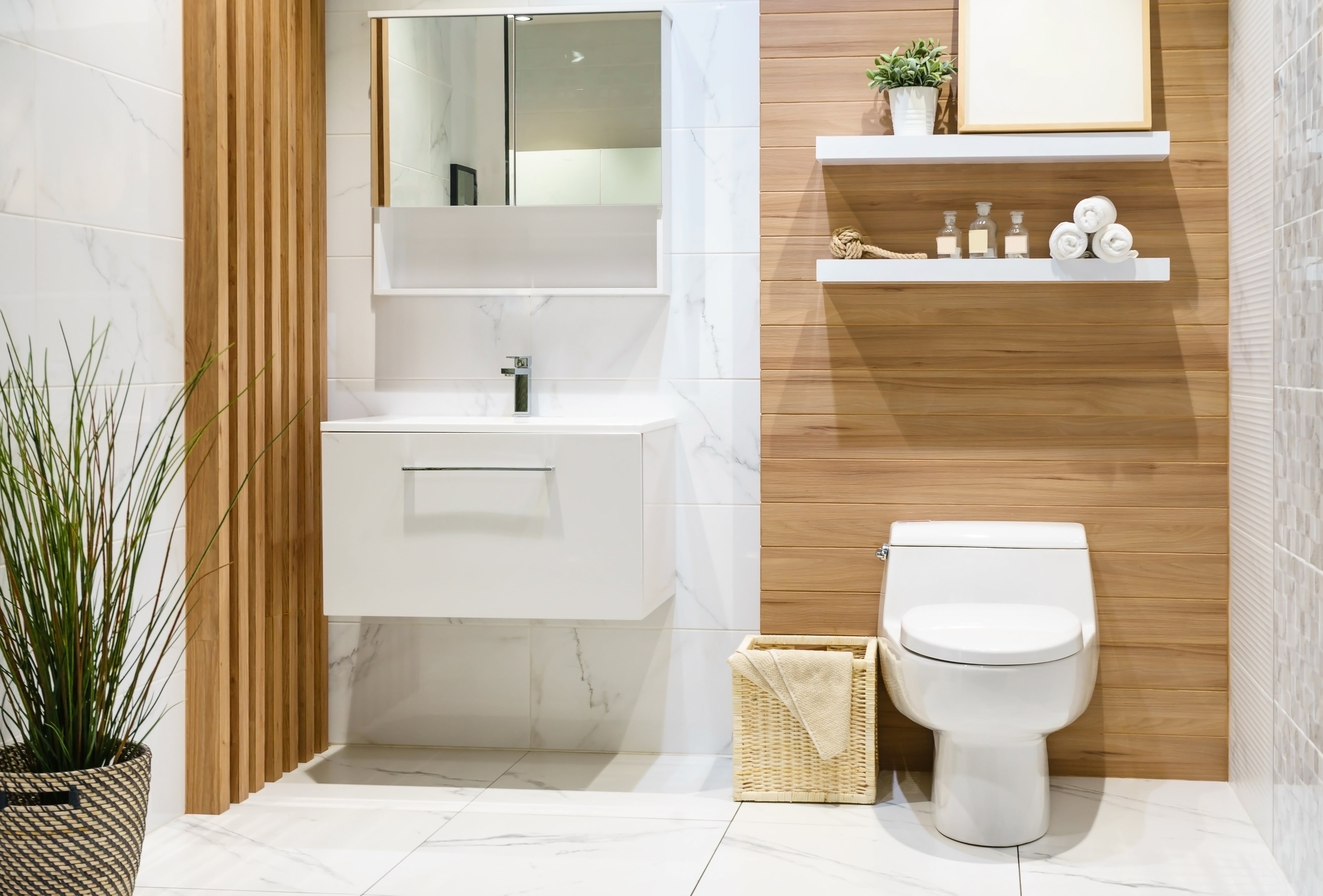 White tile bathroom with wood shiplap accent wall behind toilet