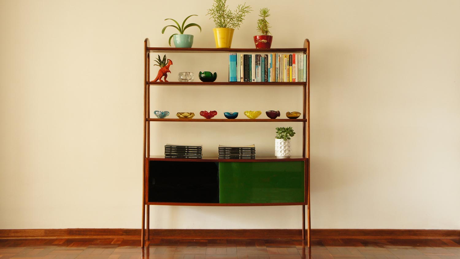 A vintage wooden bookshelf with books and plants