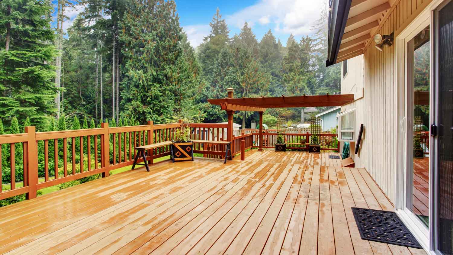 A second-story deck with a wooden pergola