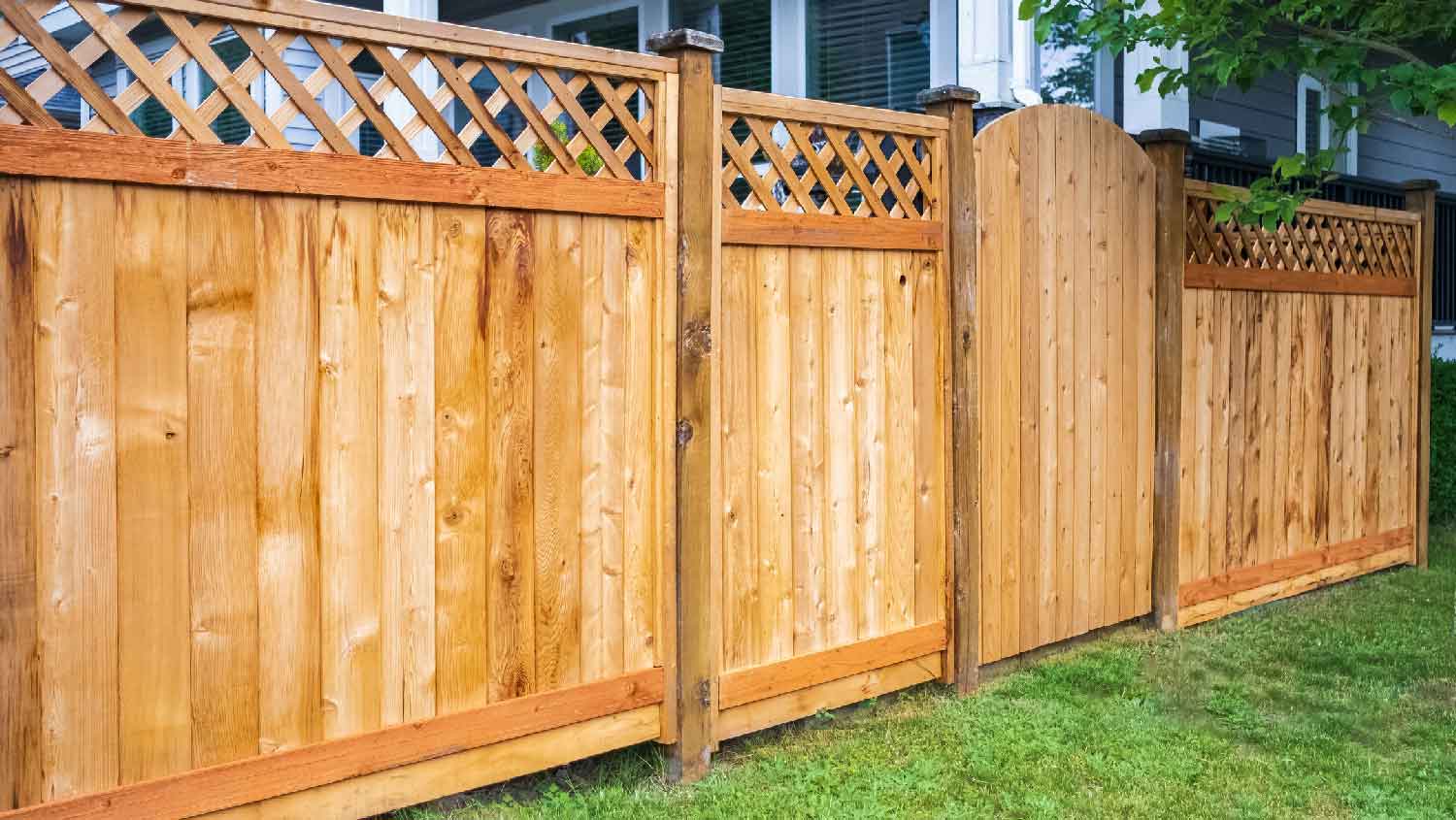 A wooden fence with green lawn