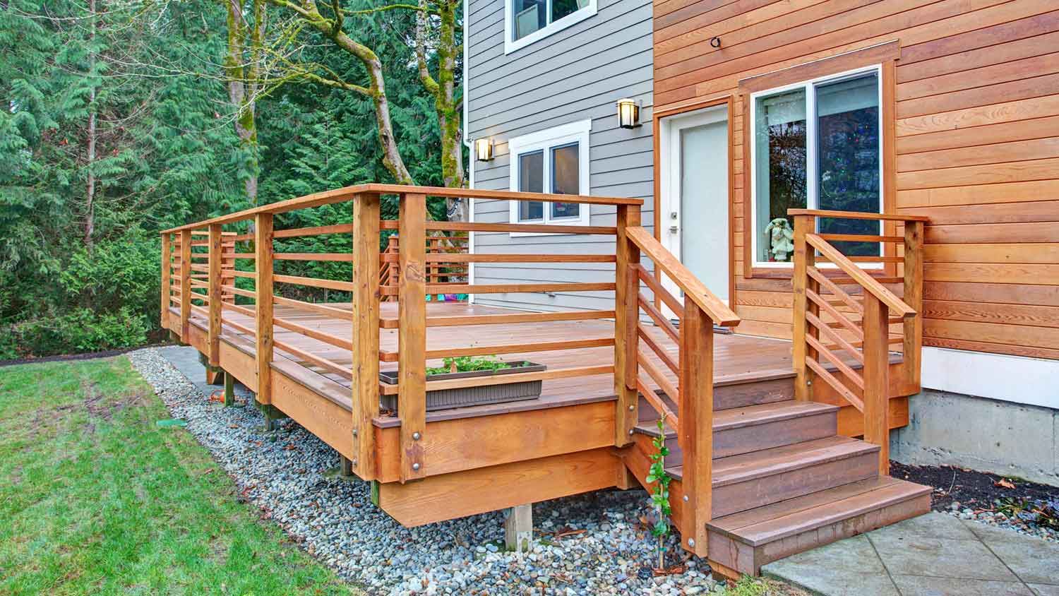 Raised wooden deck installed next to the house