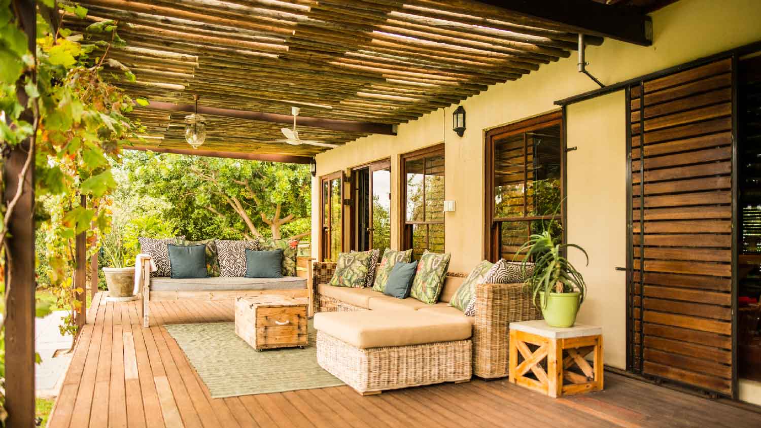 A wooden patio with furniture on a sunny afternoon