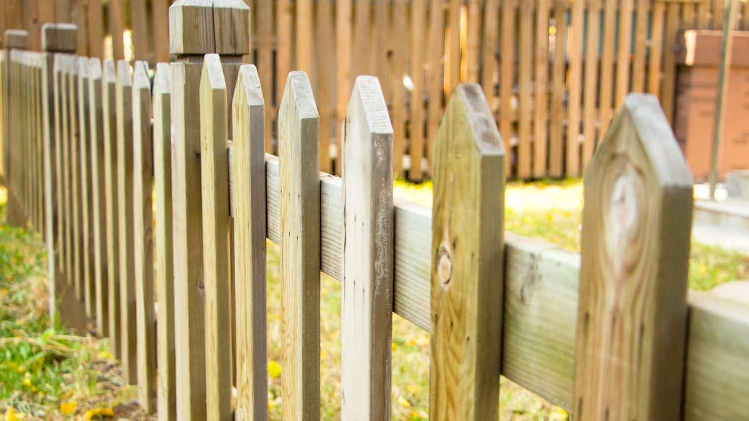 Close-up of a wooden picket fence in a yard 