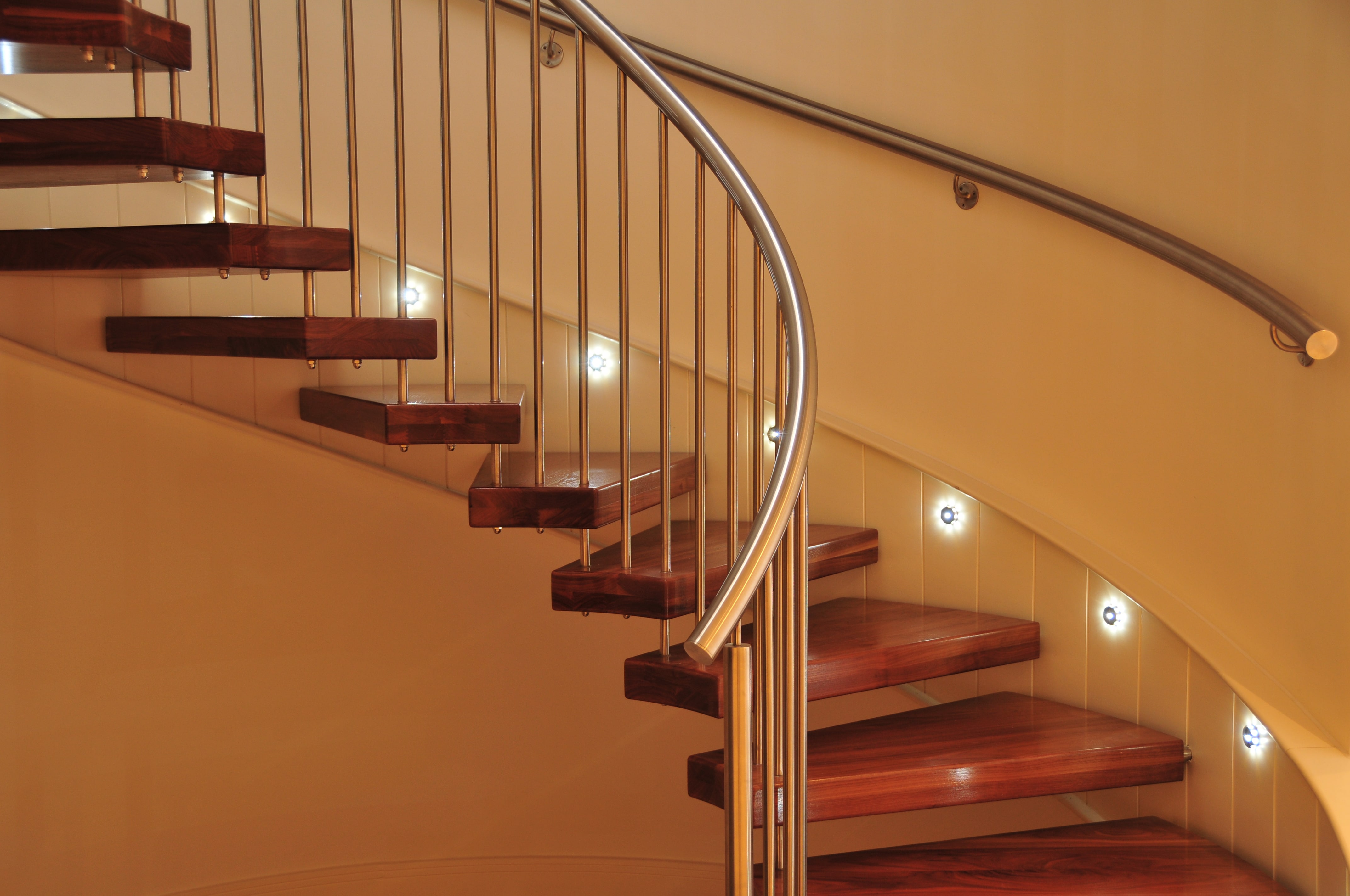 Spiral staircase lined with LED lights above stair treads