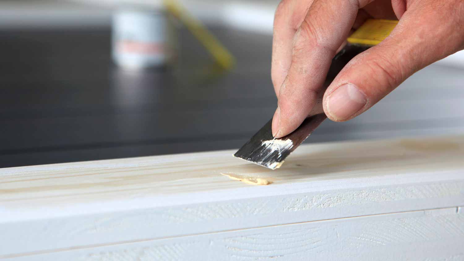 Worker applying filler to the wood