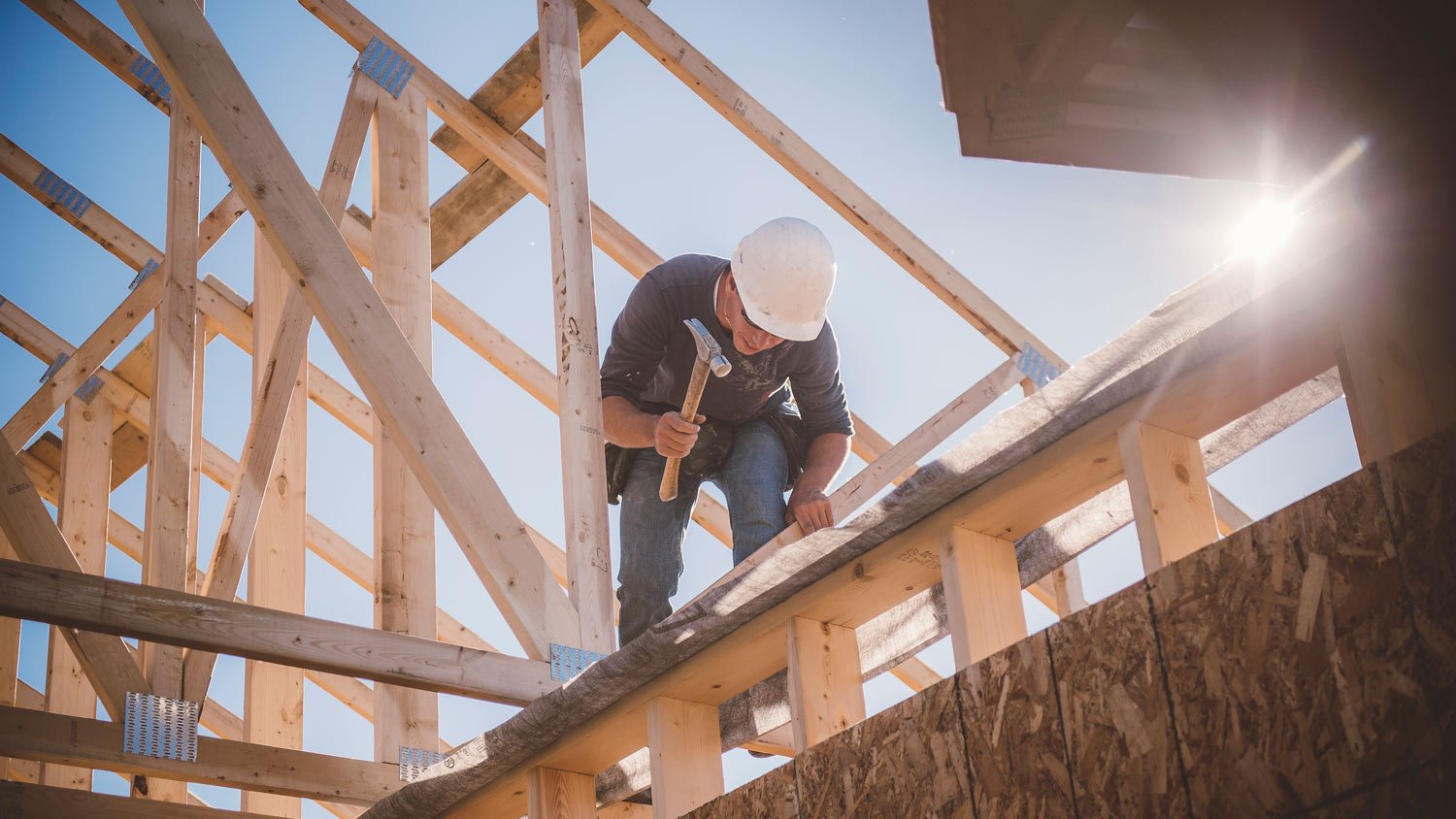 A worker building a house frame