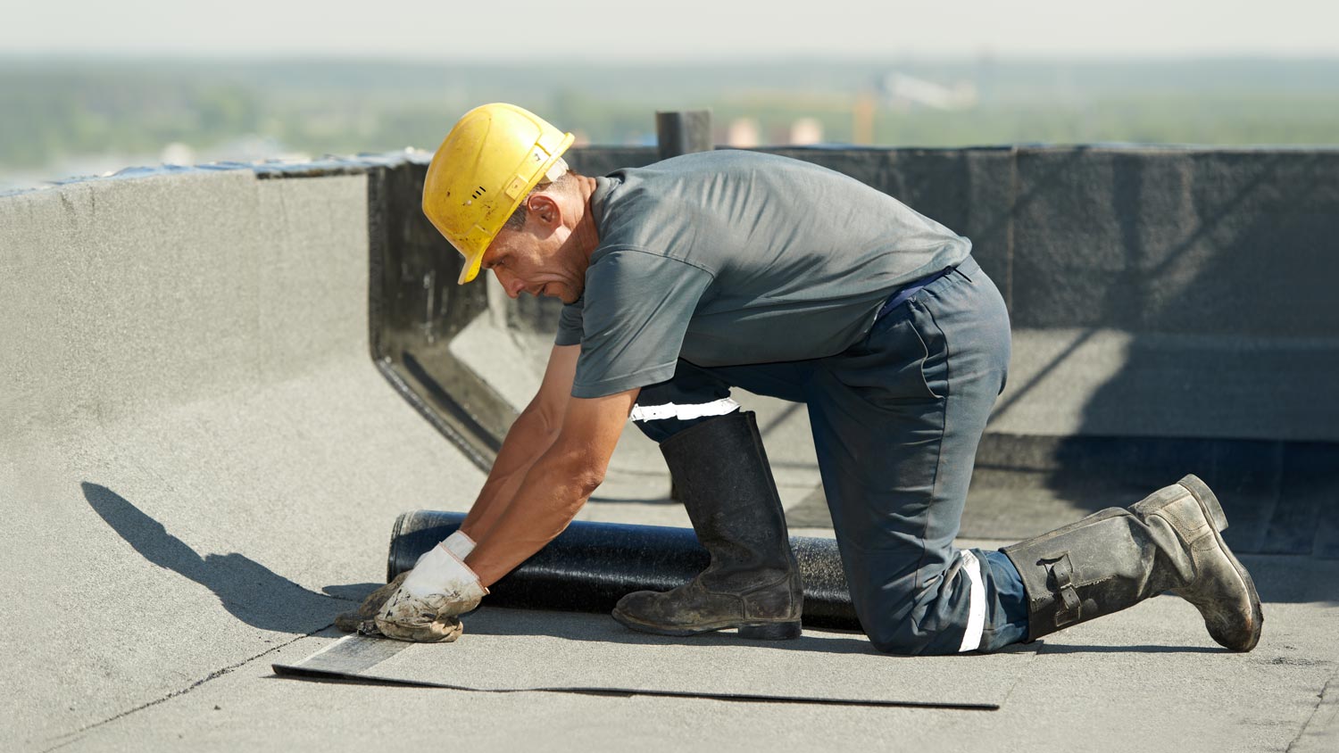 A worker coating a flat roof