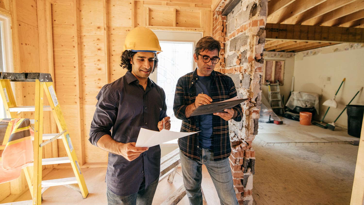 A worker and a contractor discussing renovation plans
