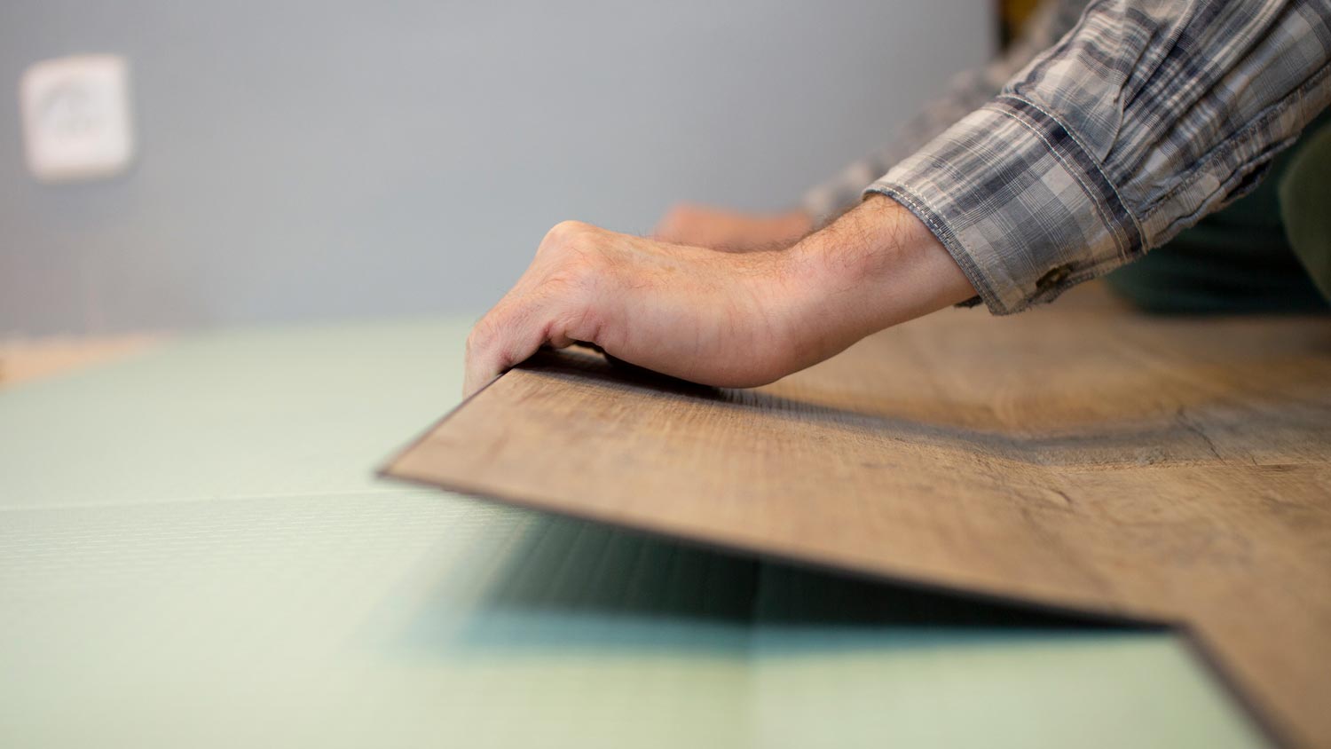 A worker installing LVT flooring