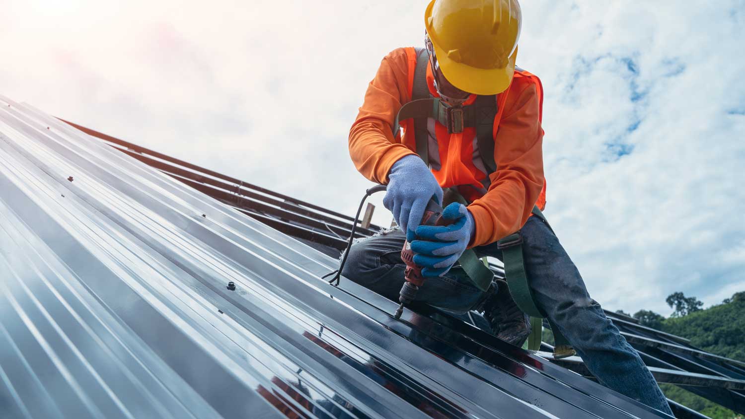 A worker installing new metal roof