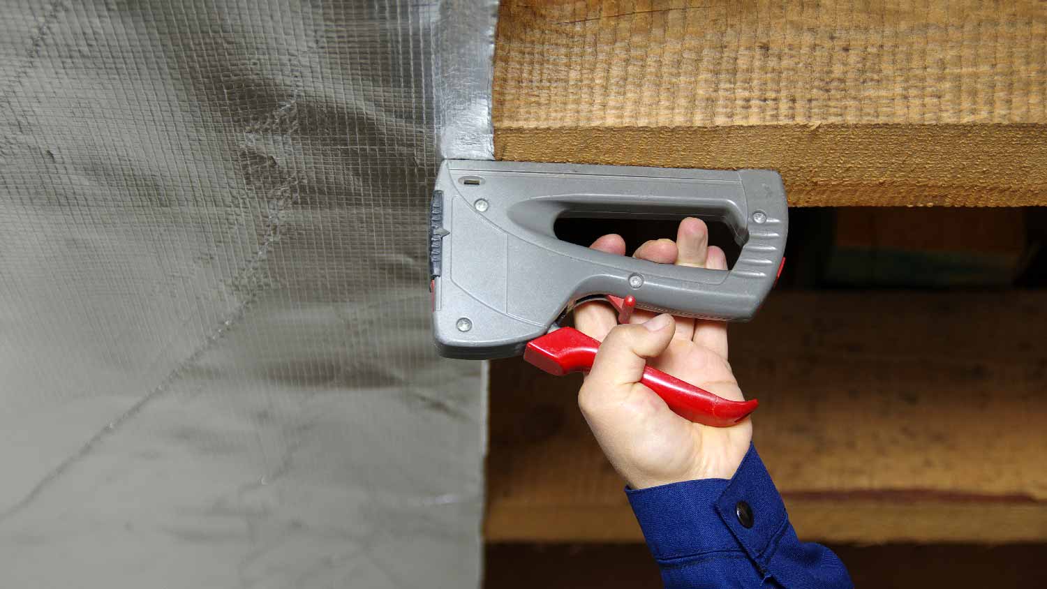 A worker installing a radiant barrier