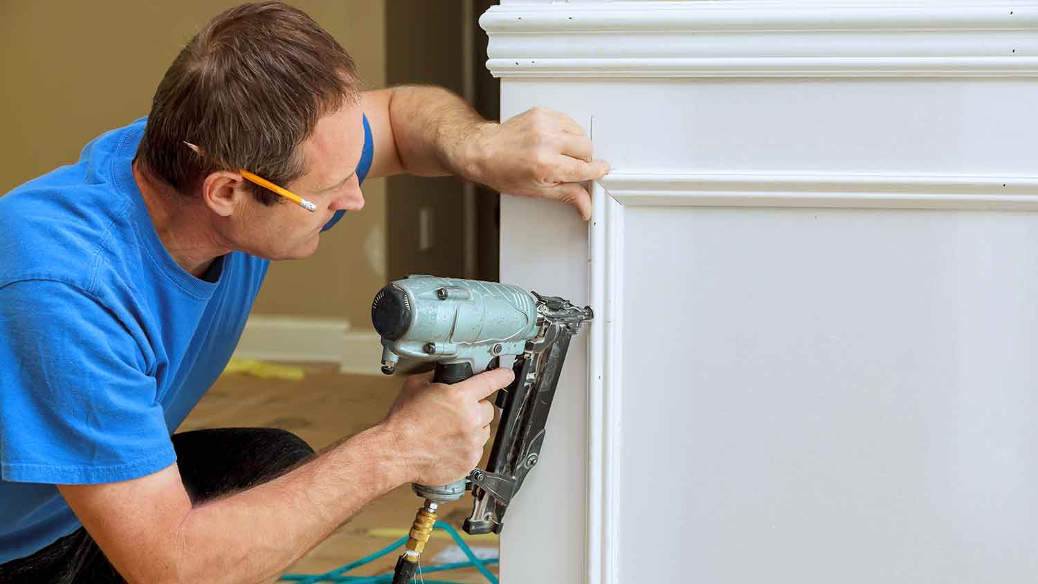 Worker installing decorative trim on the wall