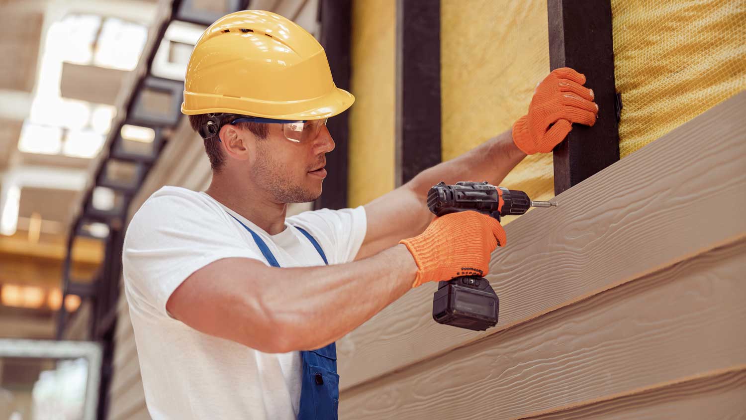 A worker installing wood siding