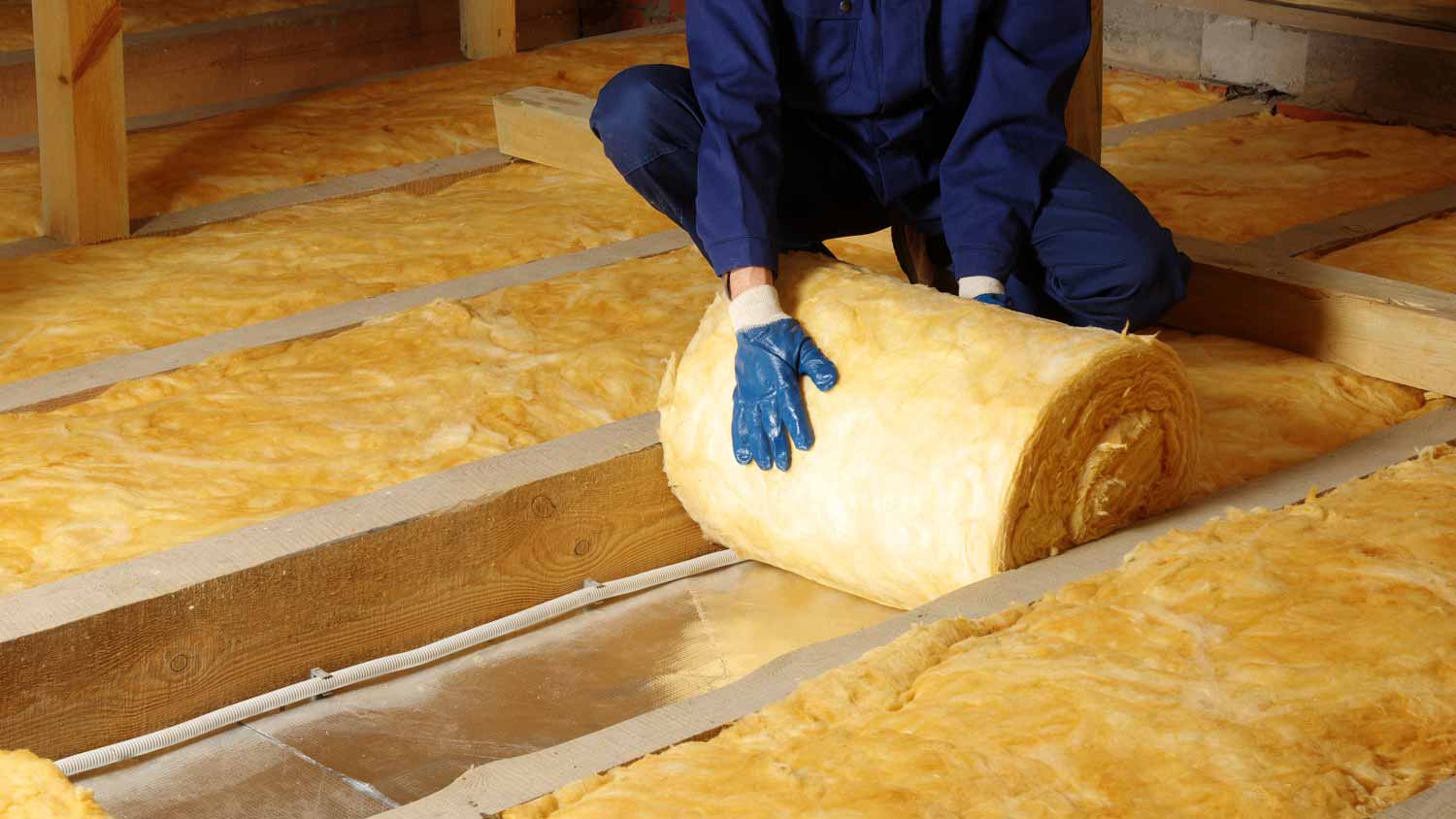 A worker insulating a house attic