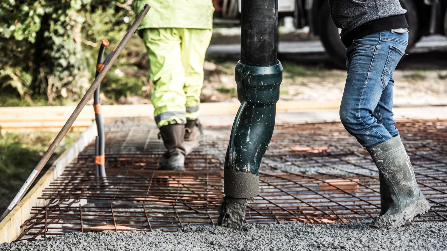 Construction worker pouring concrete screed for a house