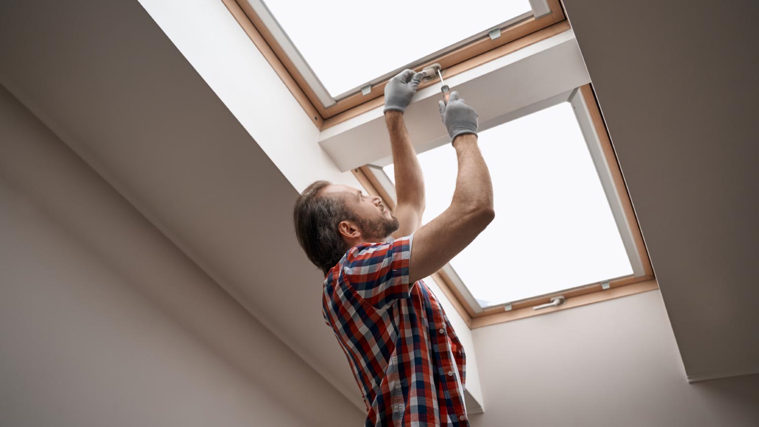 A worker screwing skylight window