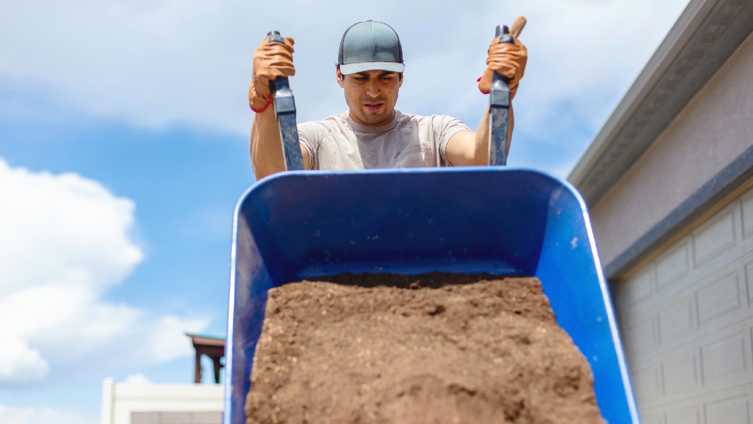 A worker unloading topsoil