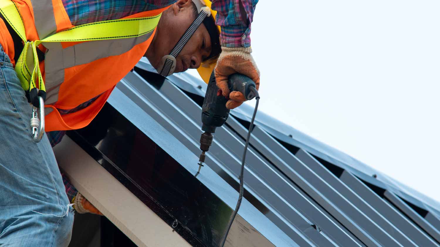 Worker wearing safety harness and working