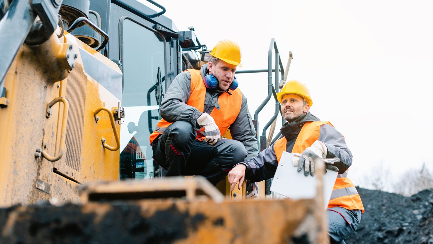 Two workers discussing on a construction field during winter