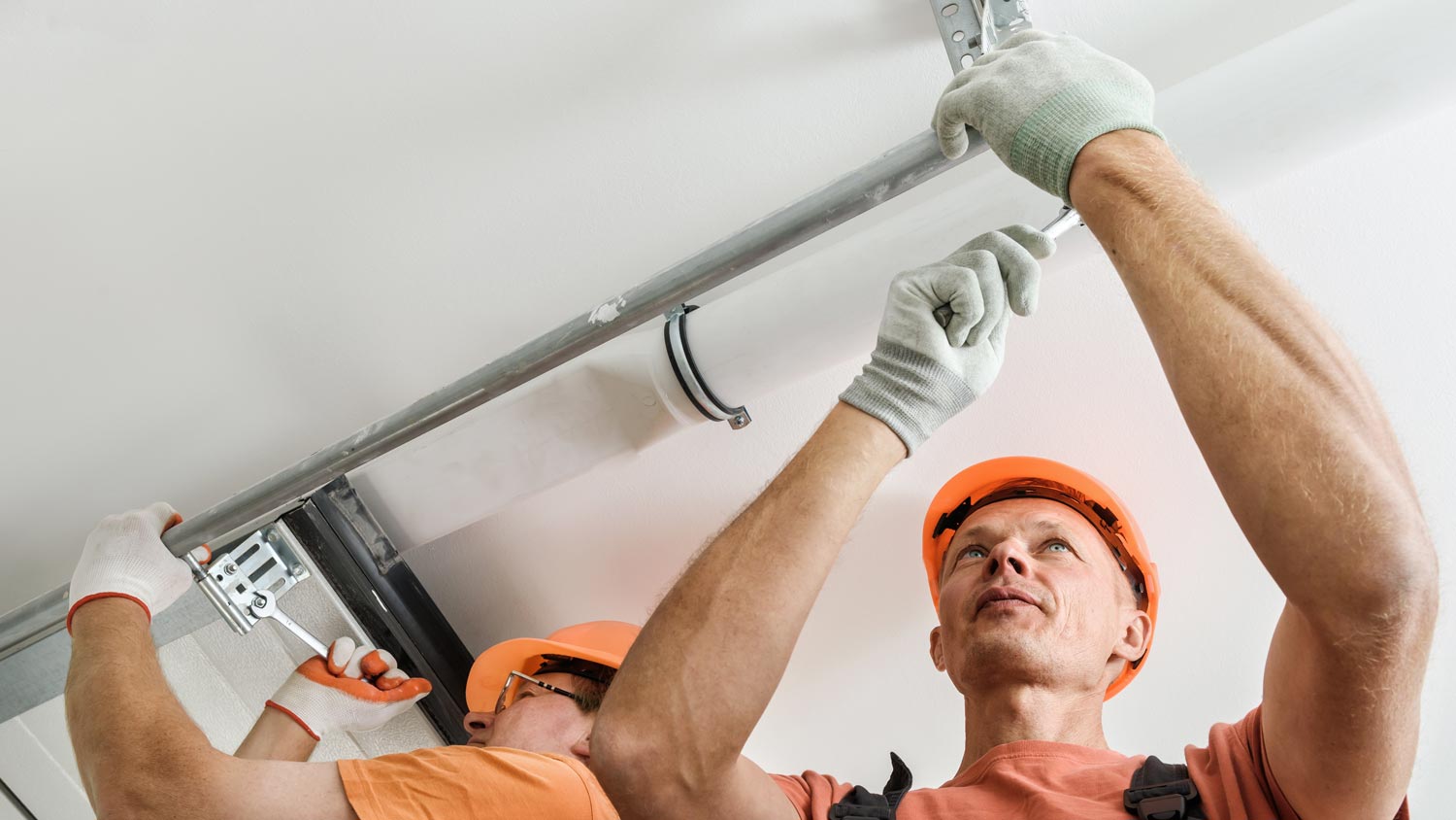 Workers installing lift gates to a garage