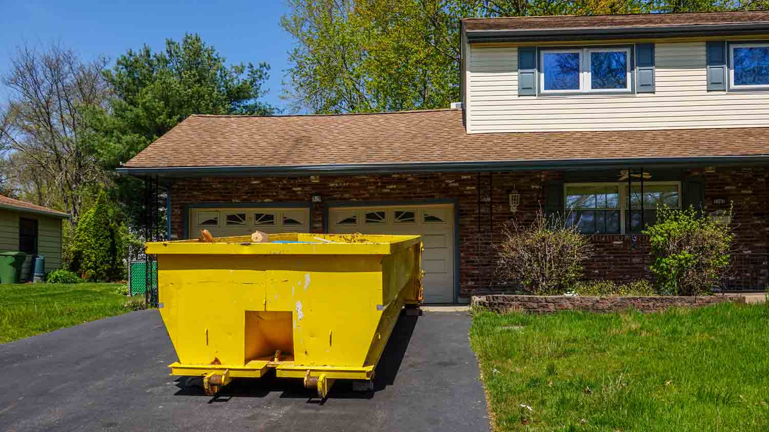 yellow dumpster in driveway