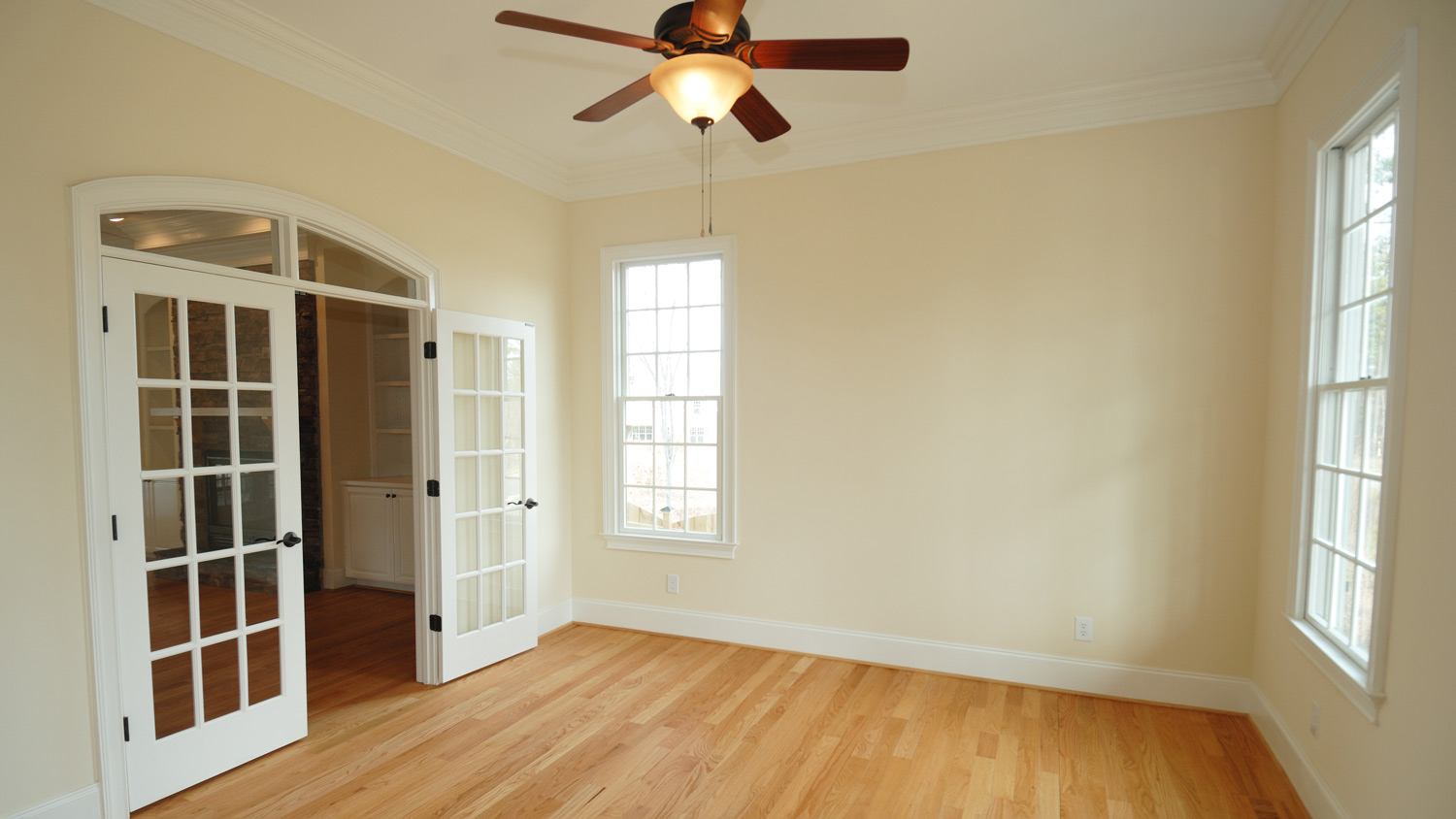View of an empty room showing a roof fan and open door