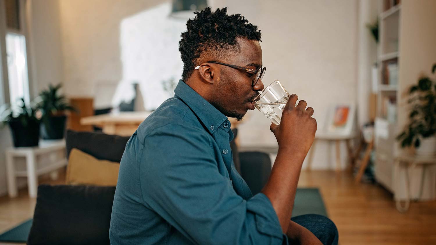 A young man drinking water from a glass