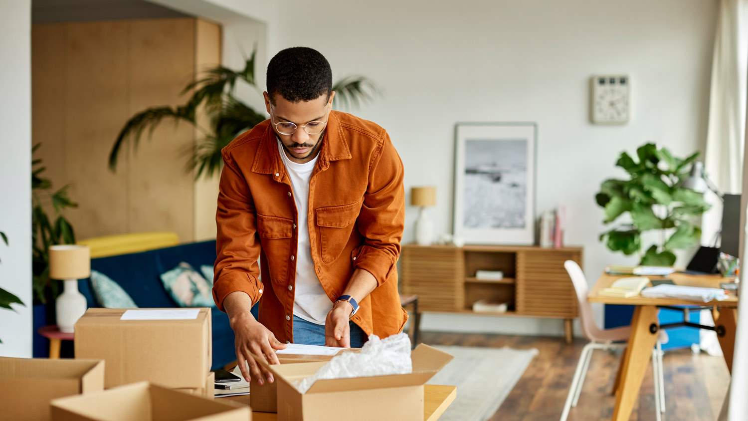 A young man packing boxes at his house