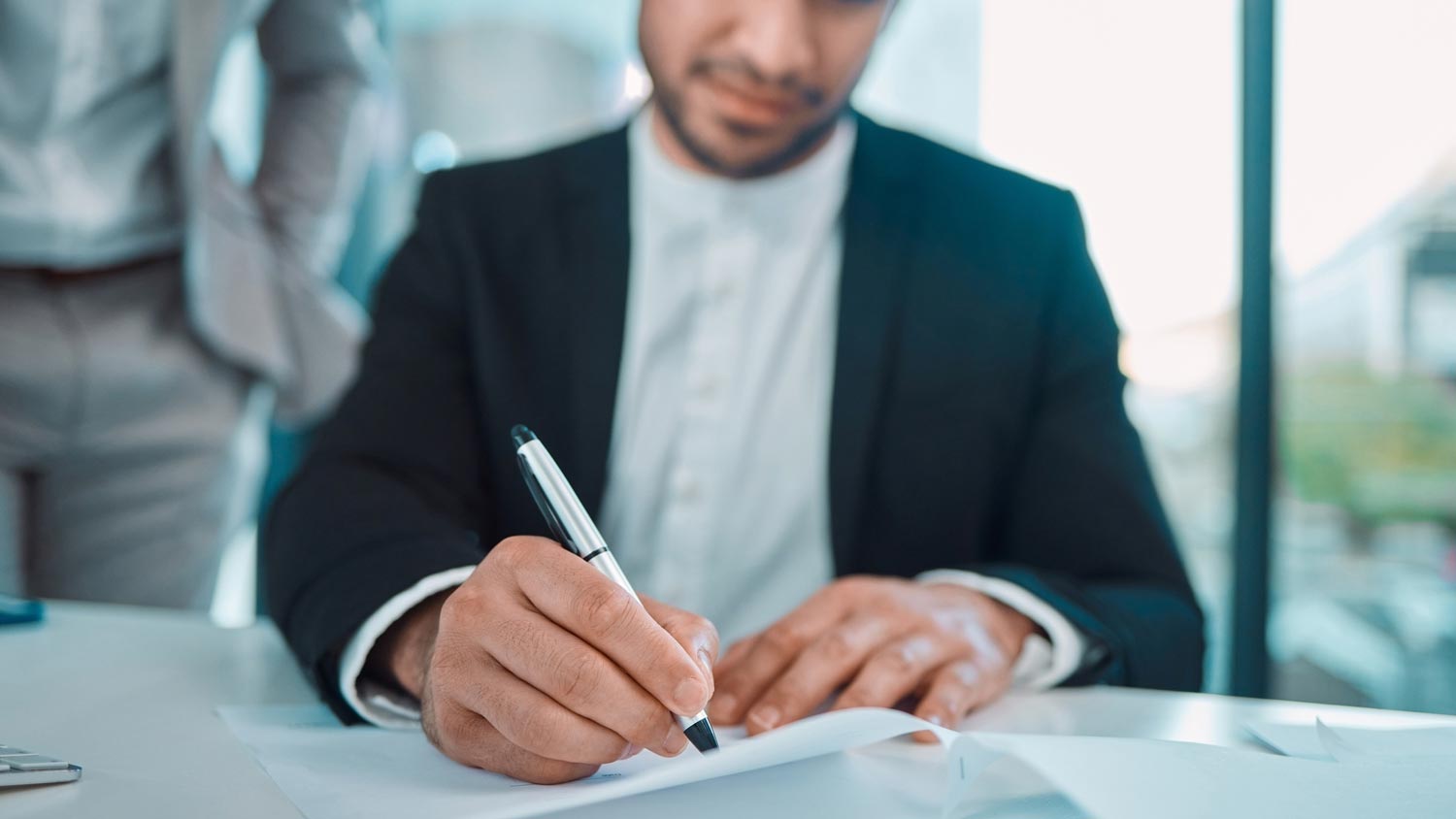 A young man signing a home loan contract