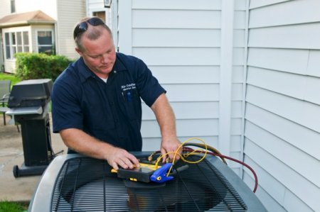 HVAC technician inspecting a/c unit