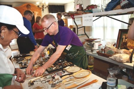 Mark Whitney Pittman, owner of highly rated Attics to Basements Estate Sales in Dallas, works on organizing items during an estate sale. (Photo by Lisa Means)