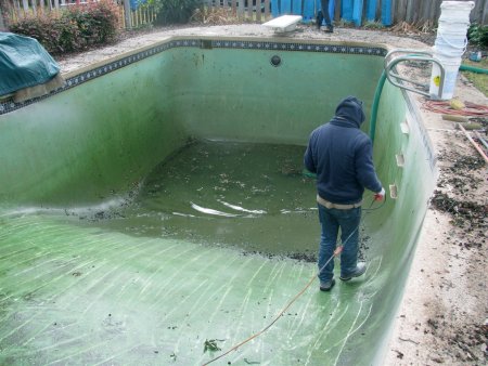 worker drains a pool to get it ready for a pool resurface