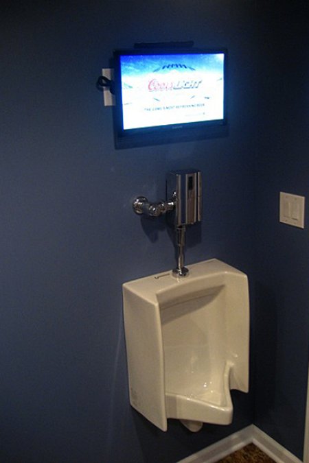 Putting a TV above the urinal in his man cave ensures no one will miss a second of the game. (Photo by Jim Brown)