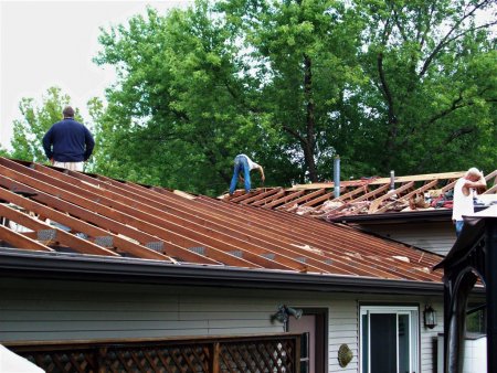 workers doing roof repair on a home