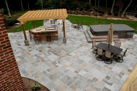 a stamped concrete patio with pergola a hot tub