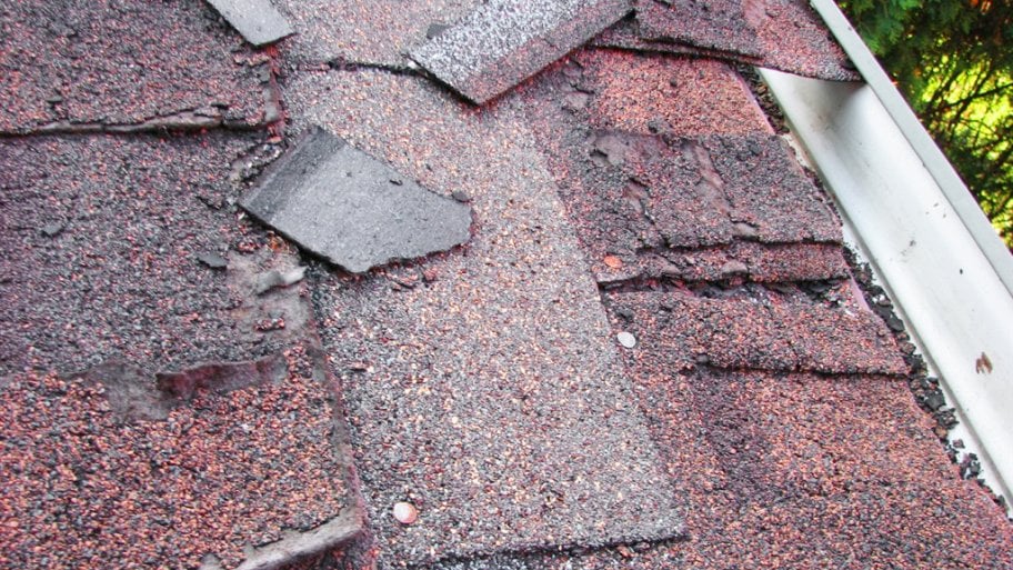 two layers of crumbling asphalt shingles