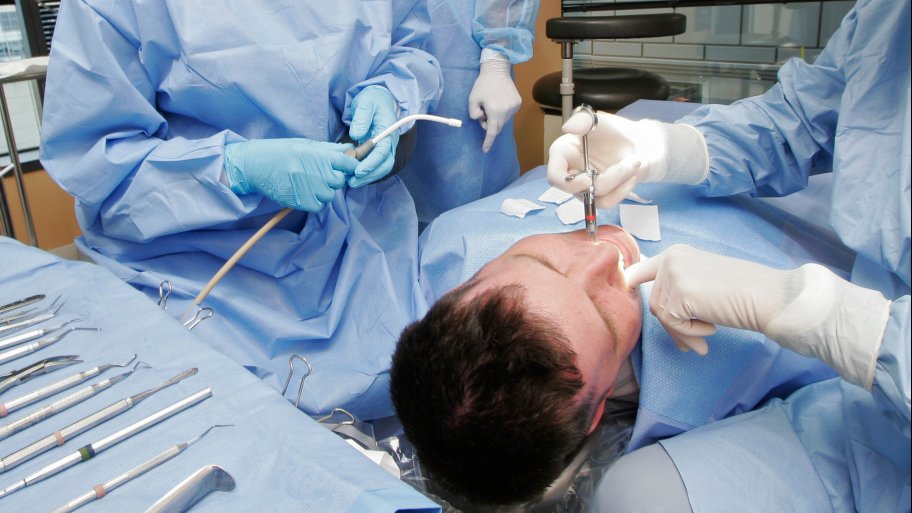 dentist in scrubs working on patient