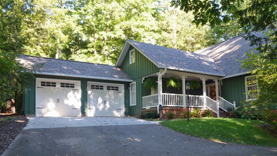 green house with carriage garage doors