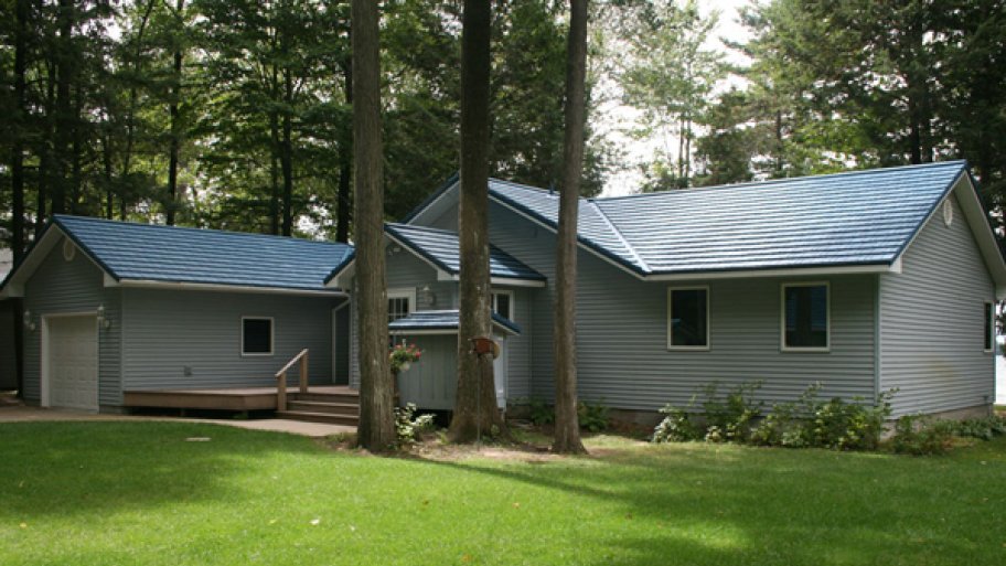 gray sided home with blue metal roof