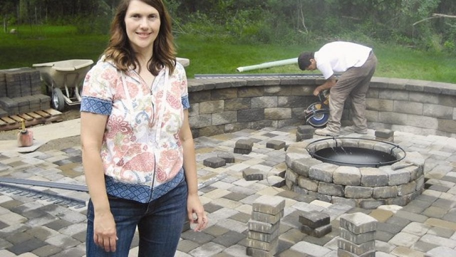 homeowner stands on new paver patio