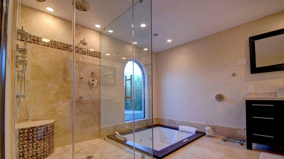 remodeled bathroom with jacuzzi tub, multiple shower heads tile