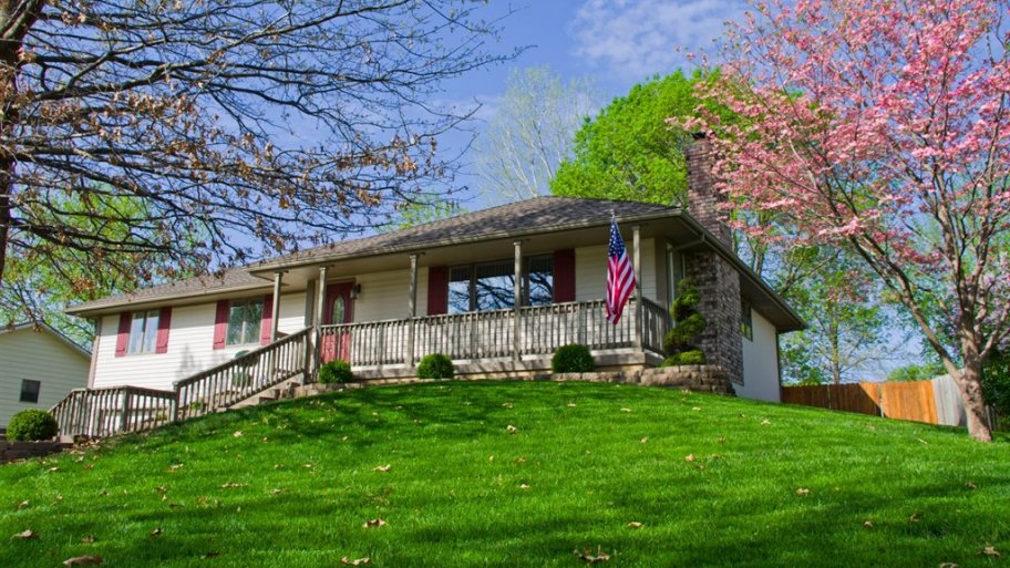 one-story home on a hill with green lawn